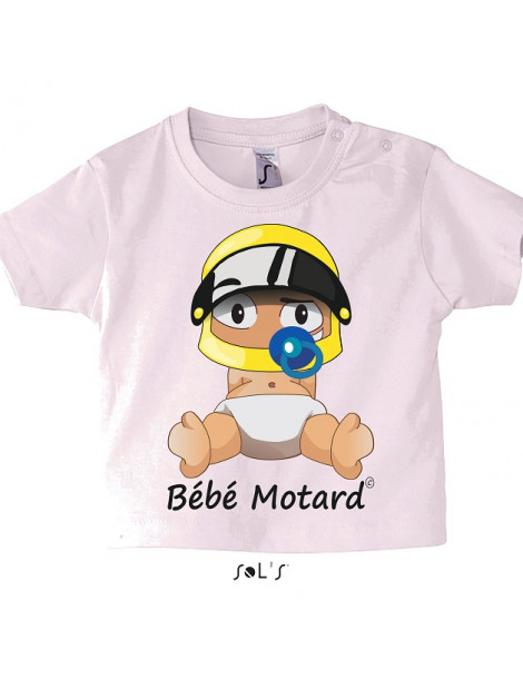 Tee-shirt bébé rose pale avec un petit bébé motard assis portant un casque jaune - vue de face